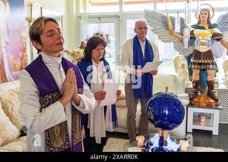 Spiritual Angel Service leader spirituale femminile , intermedia tra angeli e umani, che svolge un servizio a una coupé di seguaci e credenti dal suo salotto residenziale. Dongen, Paesi Bassi. Dongen Magnoliastraat 5 Noord-Brabant Nederland Copyright: XGuidoxKoppesx Foto Stock