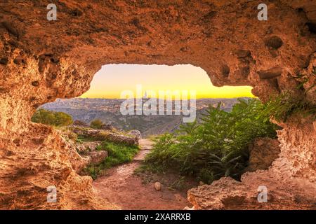 Matera, Italia come si vede dall'interno di un'antica grotta al crepuscolo. Foto Stock