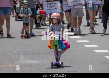 Boston, Massachusetts, USA 8 giugno 2024. Una giovane ragazza su uno scooter, che indossa un abito arcobaleno e un casco rosa, nella parata del Boston Gay Pride per le strade di Boston è durata 2 ore. La parata aveva centinaia di manifestanti e migliaia di spettatori. (Rick Friedman ) Foto Stock