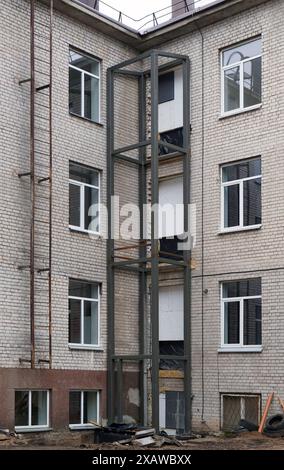 Costruzione di un ascensore esterno per disabili in un vecchio edificio in mattoni Foto Stock