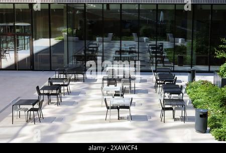 Tavoli e sedie in una caffetteria vuota accanto all'ufficio Foto Stock