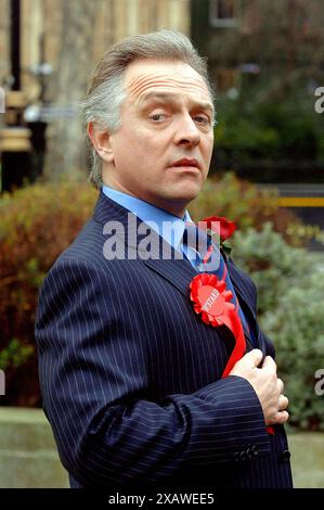 Foto del file datata 20/03/06 di Rik Mayall che torna come "il nuovo Statesman", Alan B'Stard, per lanciare un tour teatrale nazionale lunedì 20 marzo 2006, fuori dalla camera dei comuni, nel centro di Londra. Mayall 'ha aperto la porta a molti dei giovani comici alternativi che escono oggi', ha detto un produttore che ha lavorato con il comico e attore. Data di pubblicazione: Domenica 9 giugno 2024. Foto Stock