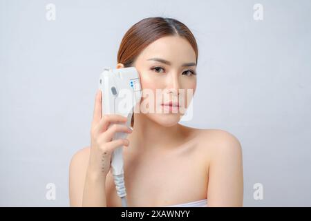 Affascinante donna asiatica che riceve la terapia laser HIFU presso la Cosmetic Clinic Foto Stock