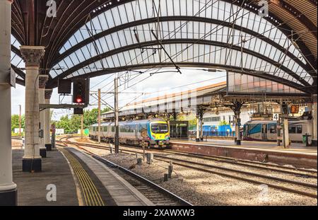 Lo storico arco curvilineo copre la piattaforma della stazione ferroviaria e le colonne fiancheggiano la piattaforma. I treni si trovano alle banchine far. Foto Stock