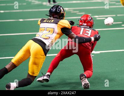 Jacksonville, Florida, Stati Uniti. 8 giugno 2024. Indoor Football League, Jacksonville Sharks vs Tulsa Oilers. Sharks WR DJ Stubbs (13) fa un'immersione mentre è ben coperto da Oilers DB Kaytron Allen (22). Foto: Tim Davis/Alamy Live News Foto Stock