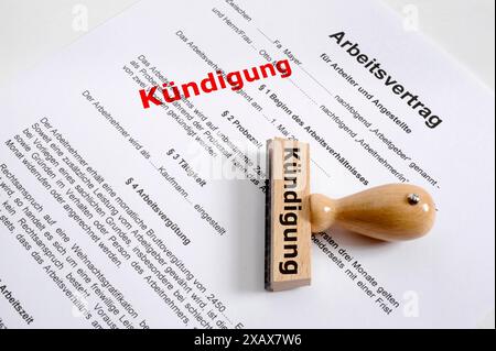 Kündigung von Arbeitsvertrag und Arbeitsplatz Ein Holzstempel liegt auf einem Arbeitsvertrag mit der Aufschrift Kündigung *** cessazione degli impiegati Foto Stock