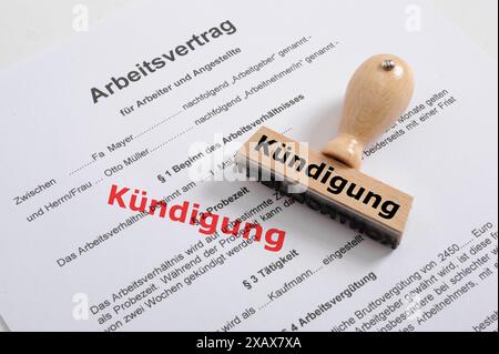 Kündigung von Arbeitsvertrag und Arbeitsplatz Ein Holzstempel liegt auf einem Arbeitsvertrag mit der Aufschrift Kündigung *** cessazione degli impiegati Foto Stock