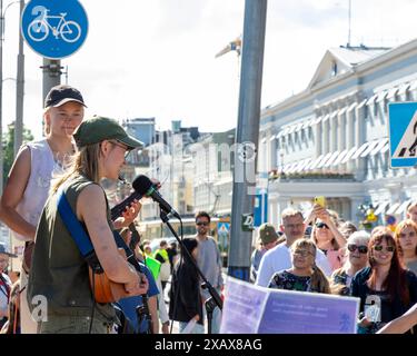 Artisti musicali nella protesta «Storm warning» tenuta dalla Extinction Rebellion Finland nella piazza del mercato, nel centro di Helsinki, il 7 giugno 2024 Foto Stock