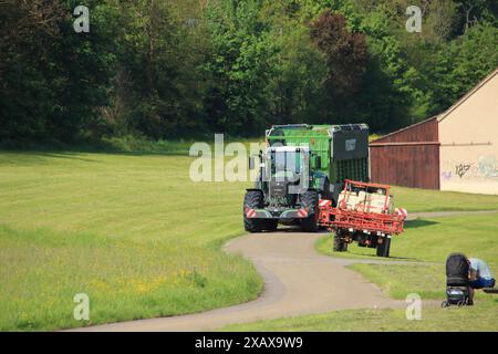 Incontro di un trattore grande e piccolo su una strada sterrata Foto Stock