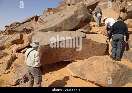 Viaggiatori che cercano i petroglifi a Taghit, nell'Algeria occidentale Foto Stock