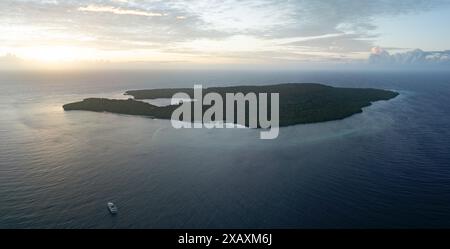 Le acque calme bagnano la costa panoramica di un'isola remota nelle isole dimenticate dell'Indonesia orientale. Questa regione presenta un'elevata biodiversità marina. Foto Stock