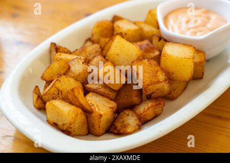 Patatas bravas (patate piccanti) Uno spuntino ​​traditional in Spagna composto da patate al forno o bollite immerse in salsa, cucina spagnola Foto Stock