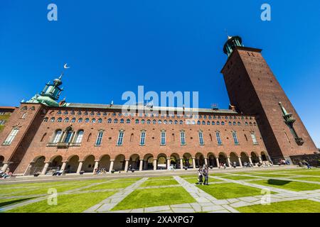 Municipio di Stoccolma (Stockholms stadshus) Stadshusträdgården, Stoccolma, Svezia. Il Municipio di Stoccolma, Stadshuset, si trova direttamente sul lungomare. Il cortile interno e la terrazza sul mare sono aperti al pubblico. Lo Stadshuset è uno dei punti di riferimento di Stoccolma. L'edificio in mattoni rossi del 1923 nel quartiere di Kungsholmen si trova direttamente sull'acqua. Vale la pena salire sulla torre per una vista fantastica su Stoccolma. Le visite guidate all'edificio sono ancora più popolari. I gruppi partono ogni minuto Foto Stock