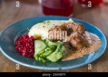 Classico svedese Köttbollar. Polpette con purè di patate, insalata di cetrioli e mirtilli rossi, polpette del ristorante per il popolo, Södermalm, Stoccolma. Tour gastronomico attraverso Stoccolma. Kocksgatan, Stoccolma, Svezia Foto Stock