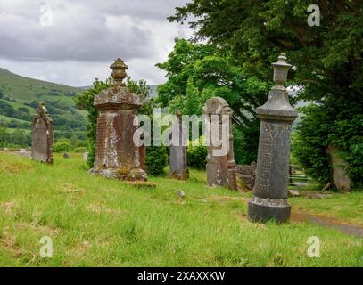 Uniche lapidi cilindriche su tombe nel cimitero di St Simon e St Jude a Llanddeusant, nei Brecon Beacons, Galles del Sud, Regno Unito Foto Stock