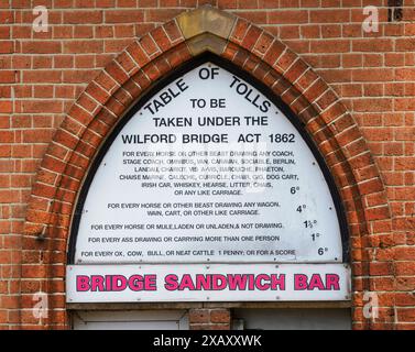 Cartelli antiquati e moderni al casello di Wilford Bridge che attraversa il fiume Trent a Nottingham, Regno Unito, dal trasporto pre-motorizzato al sandwich bar Foto Stock