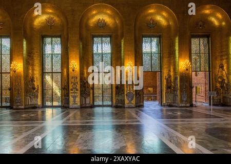 Milioni di piastrelle a mosaico realizzate in vetro e foglia d'oro reale bagnano la sala con una luce dorata unica. Dopo il banchetto del Premio Nobel, i 1.300 ospiti si spostano nella Golden Hall per ballare. Municipio di Stoccolma (Stockholms stadshus). Uffici governativi sul lungomare completati nel 1923 e realizzati in mattoni rossi con una torre con copertura a lanterna. Stadshusträdgården, Stoccolma, Svezia Foto Stock