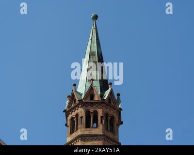 Vista dettagliata di una guglia gotica della chiesa di fronte a un cielo azzurro, suggestiva e maestosa, Wuerzburg, Baviera, Germania Foto Stock