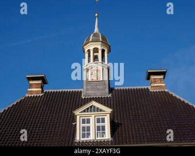 Campanile su un vecchio edificio con una faccia dell'orologio davanti a un cielo azzurro, Leer, Frisia Orientale, Germania Foto Stock