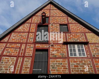 Una casa per metà in legno con mattoni rossi e gialli e travi di legno nere, contro un cielo blu, lueneburg, bassa sassonia, germania Foto Stock