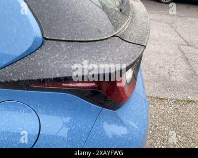 Cremona, Italia - 9 giugno 2024 dettaglio di un'auto grigia ricoperta di sabbia e polvere da una tempesta di sabbia in un ambiente urbano Foto Stock