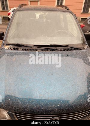 Cremona, Italia - 9 giugno 2024 l'auto blu parcheggiata in strada è completamente coperta di polvere, probabilmente il risultato di una recente tempesta di sabbia Foto Stock