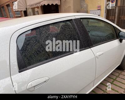 Cremona, Italia - 9 giugno 2024 le automobili sono ricoperte di polvere di sabbia mentre venti africani e nuvole dal deserto del sahara arrivavano nel nord italia, Lombardia, pioggia Foto Stock