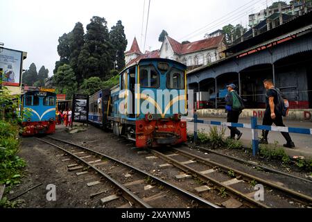 Un treno giocattolo parte dalla stazione ferroviaria di Darjeeling. La Darjeeling Himalayan Railway, nota anche come "Toy Train", è un treno ferroviario a scartamento ridotto costruito tra il 1879 e il 1881. La ferrovia si sposta fino a un livello di altitudine di 2.200 metri (7.218 piedi). Quattro moderne locomotive diesel gestiscono la maggior parte dei servizi di linea; tuttavia i treni turistici giornalieri da Darjeeling a Ghum (la stazione ferroviaria più alta dell'India) sono gestiti dalle locomotive a vapore vintage di costruzione britannica classe B. Il DHR è stato dichiarato patrimonio dell'umanità dall'UNESCO nel 1999. Foto Stock