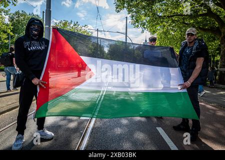 Rotterdam, Olanda meridionale, Paesi Bassi. 9 giugno 2024. Due manifestanti detengono una bandiera della Palestina. Il 9 giugno 2024, protestando contro le recenti misure e la violenza di Rafah da parte di Israele, i manifestanti filo-palestinesi hanno marciato attraverso Rotterdam, Paesi Bassi. (Credit Image: © James Petermeier/ZUMA Press Wire) SOLO PER USO EDITORIALE! Non per USO commerciale! Foto Stock