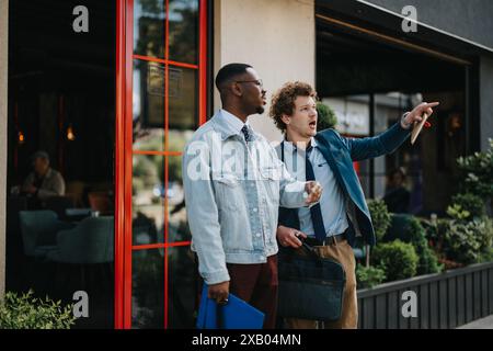 Partner commerciali multirazziali che discutono idee di progetti all'aperto in città Foto Stock