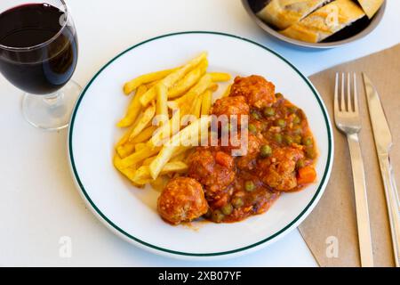 Polpette in stile giardino cotte con verdure servite con patatine fritte Foto Stock