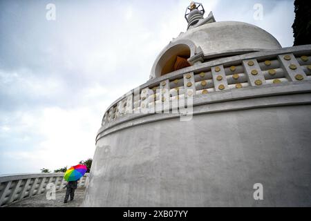 Darjeeling, Bengala Occidentale, India. 8 giugno 2024. Una donna cammina con un ombrello alla Peace Pagoda, il monastero buddista vicino a Darjeeling. (Immagine di credito: © Avishek Das/SOPA Images via ZUMA Press Wire) SOLO PER USO EDITORIALE! Non per USO commerciale! Foto Stock