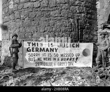 Mostra questo cartello di fronte alla cittadella di Julich, Germania - sulla PFC. Thomas Snyder, New York City, e Pvt. Paul Mattox, Washington, D.C., entrambi della compagnia C, 175th Infantry Regiment, 29th Infantry Division, Nona U.S. Army. 24 febbraio 1945. Compagnia C, 175th Infantry Regiment, 29th Infantry Division. Fotografo: T/4 Paul C. strong. Data 24 febbraio 1945 Foto Stock