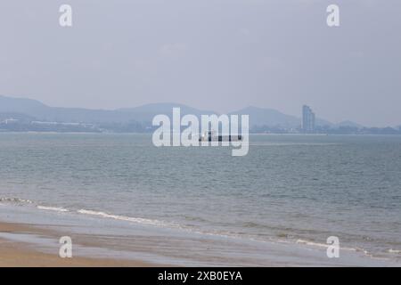 La barca aspirante di sabbia ormeggiata sulla riva del mare di Jomtien Beach della città di Pattaya e le barche succhieranno la sabbia e riempiranno la spiaggia per aumentare l'area della spiaggia. Foto Stock