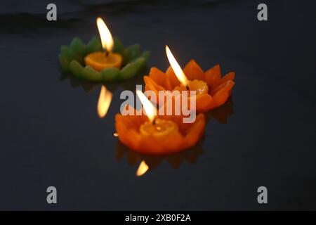 Candele di Krathong con fiamme che galleggiano sull'acqua, Un rituale buddista che si crede rimuova le cose cattive dalla vita quando le candele galleggiano. Foto Stock