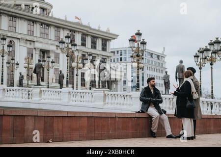 Due giovani, impegnati in una seria discussione d'affari in una città urbana. Cattura l'essenza del lavoro a distanza e dell'imprenditorialità. Foto Stock