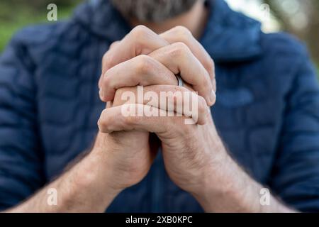 Mani preghiere di un giovane uomo Foto Stock