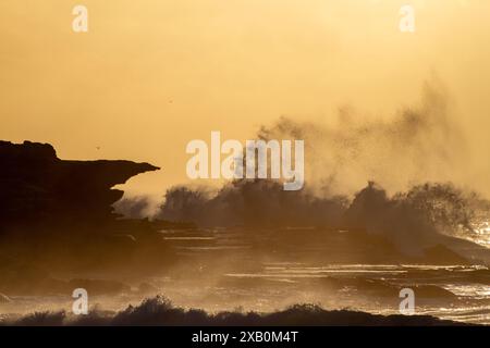 Alba sulla spiaggia di Maroubra a Sydney, Australia, con le onde che si infrangono sulle scogliere Foto Stock