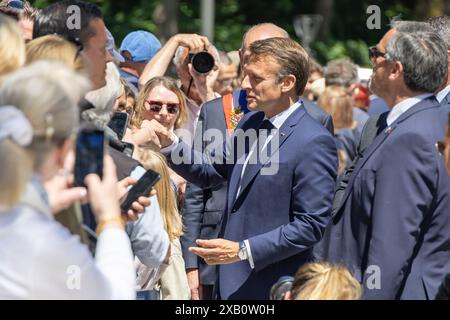 Le Touquet. 9 giugno 2024. Il presidente francese Emmanuel Macron (2° R) saluta i residenti al di fuori di un seggio elettorale al suo arrivo per votare per le elezioni del Parlamento europeo a le Touquet, in Francia, il 9 giugno 2024. Macron ha annunciato lo scioglimento dell'Assemblea nazionale e ha indetto nuove elezioni legislative domenica sera dopo che il suo partito rinascimentale ha subito una pesante sconfitta alle elezioni del Parlamento europeo (EP), secondo una trasmissione in diretta dei media locali BFMTV. Crediti: Frank Boham/Xinhua/Alamy Live News Foto Stock