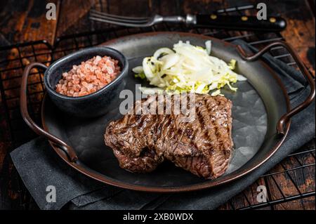 Bistecca di cervo con sale marino e insalata. Sfondo di legno. Vista dall'alto. Foto Stock