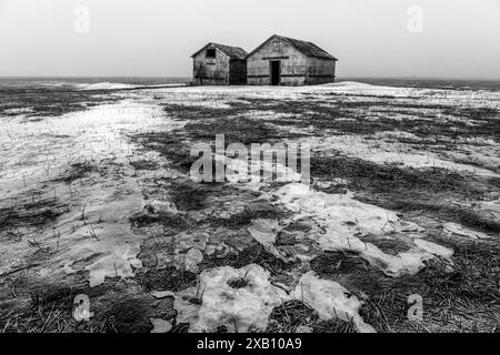 Due capannoni abbandonati e degradati sulla fredda tundra del Canada. Foto Stock