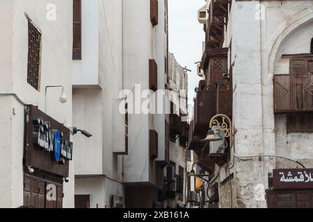 Jeddah, Arabia Saudita - 21 dicembre 2022: Uno stretto vicolo nello storico quartiere di al-Balad presenta un'architettura tradizionale con intricate ba di legno Foto Stock