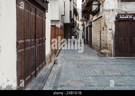 Jeddah, Arabia Saudita - 21 dicembre 2022: Una figura solitaria passeggia attraverso i vicoli storici della città vecchia. Foto Stock