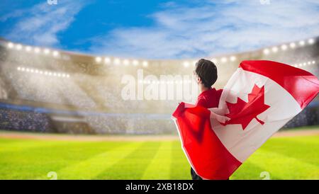 Tifoso del Canada nello stadio. Tifosi canadesi che giocano a calcio o hockey sul campo e che guardano le partite della squadra. Gruppo di tifosi con bandiera e maglia nazionale Foto Stock