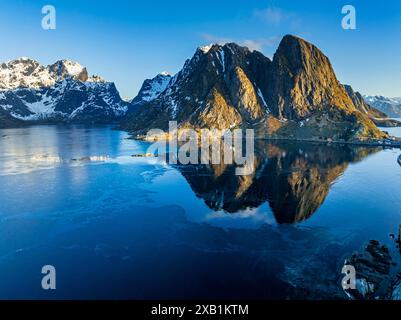 Vista aerea, villaggio, ponte, montagne lungo la costa, inverno, Sun, Reine, Kjerkfjorden, Lofoten, Norvegia, Europa Foto Stock