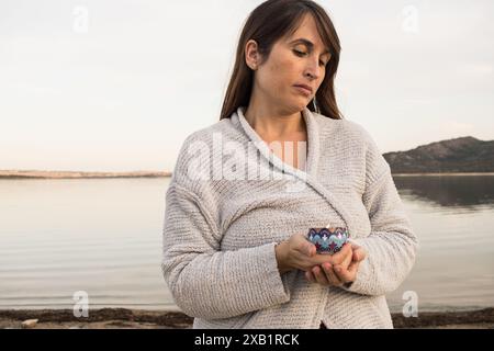 donna di bellezza che tiene in mano una candela blu. Meditazione. Relax. aromaterapia. concetto. Orizzontale Foto Stock