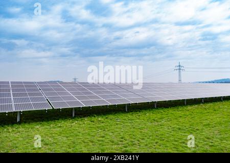 Le file di pannelli fotovoltaici si estendono attraverso le fattorie solari, catturando l'energia solare per un futuro sostenibile, l'energia pulita delle fattorie solari, generando elettricità fr Foto Stock