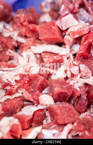 Carne cruda tagliata a dadini su una linea di produzione di fabbrica Foto Stock