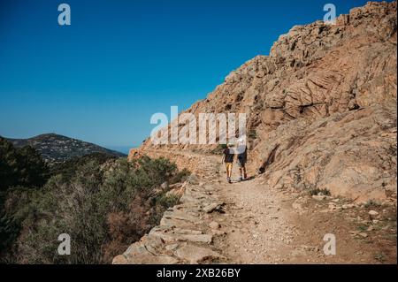 Due ragazzi che camminano nelle aspre montagne della Corsica che si affacciano sul mare Foto Stock