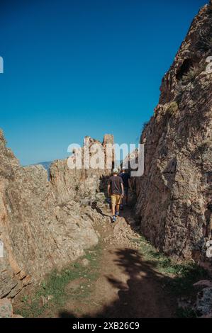 Due ragazzi che camminano nelle aspre montagne della Corsica che si affacciano sul mare Foto Stock